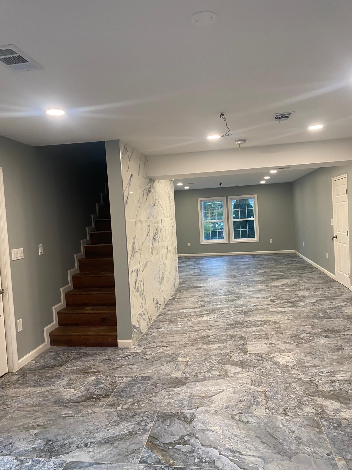 Polished marble porcelain tile flooring and wood stairs